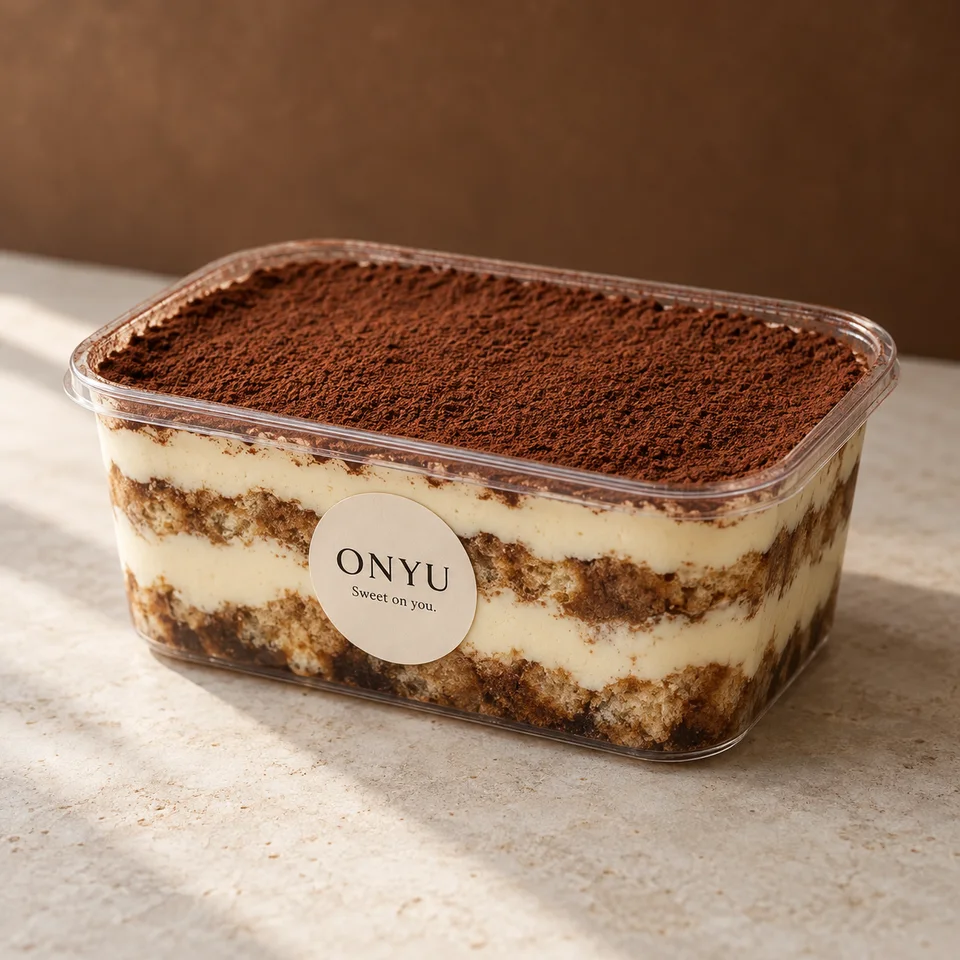 Classic cocoa tiramisu in a clear takeaway tub